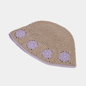 Detailed close-up of beige crochet bucket hat with purple floral knit patterns and wavy brim