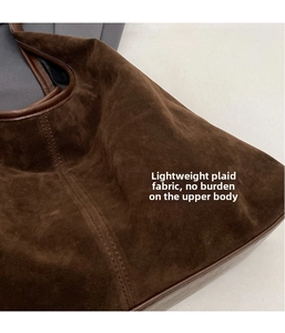 Close-up of brown faux suede tote bag featuring smooth PU leather trim and neat stitching