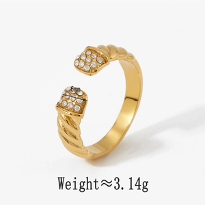 Détail d'une bague torsadée dorée avec zircons blancs, montrant la largeur de 6mm et le poids