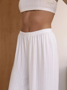 Detail of white ribbed knit loungewear set featuring elastic waist and button texture