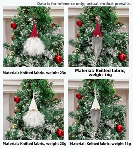 Close-up of knitted Christmas gnomes with long beards hanging on a festive tree branch