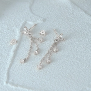 Detailed macro view of S925 sterling silver leaf stud earrings with zircon tassels