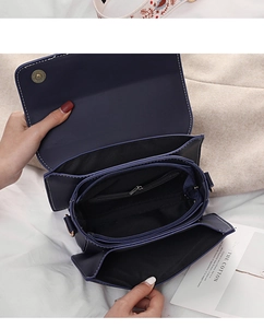 Detail view of navy blue crossbody bag interior with multi-compartments and white stitching