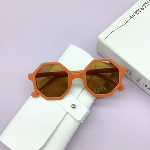 Detail of orange octagonal kids sunglasses with UV400 lenses and white storage case