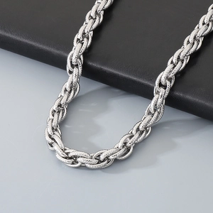 Macro shot of silver twisted curb chain necklace with unique textured metal finish