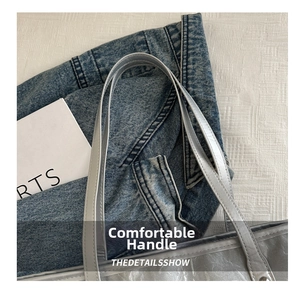 Detail of silver metallic tote bag handle featuring double-stitched reinforcement on PU leather