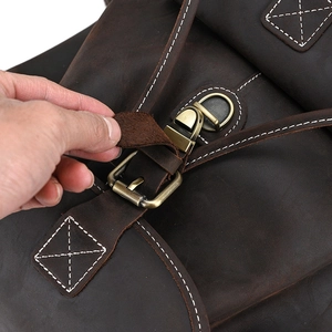 Macro detail of crazy horse leather backpack with vintage metal buckle and white stitching