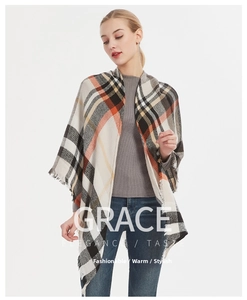 Close-up of beige and orange plaid cashmere scarf featuring detailed fringe edges