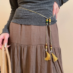 Detail of bohemian waist chain with colorful wooden beads and vibrant yellow tassels
