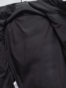 Detail view of the black puffer jacket interior featuring a white wash care label tag