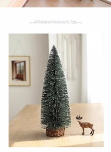 Close-up of mini snowy Christmas tree with white flocking and textured wooden base