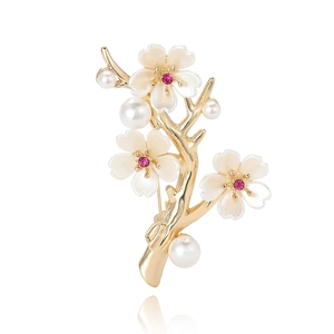 Elegant gold flower brooch with white pearl petals and pink accents on branch