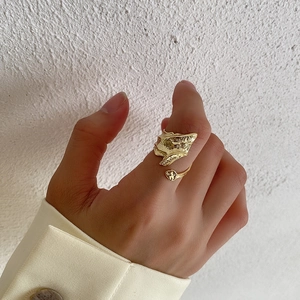 Detail of gold adjustable ring showing unique irregular molten texture on finger