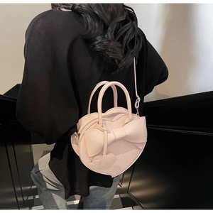 Sac à main rose en forme de cœur avec grand nœud décoratif et pendentif de détail