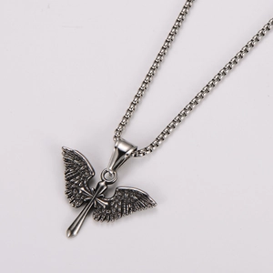 Macro shot of silver angel wing cross pendant with vintage box chain detail