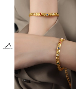 Close-up of gold-plated stainless steel bracelet with colorful rhinestones on wrist