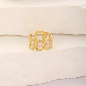 Macro detail of gold-plated open ring with hollow chain design and pink gems