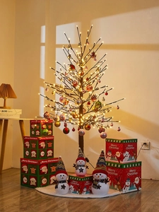 Close-up of lighted Christmas tree with colorful ornaments and snowman dolls on boxes