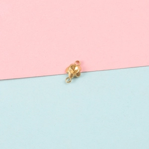 Macro view of gold-plated flower-shaped jewelry connector with stone setting base