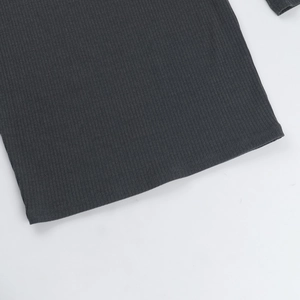 Close-up of dark grey ribbed knit fabric showing fine texture and hem craftsmanship