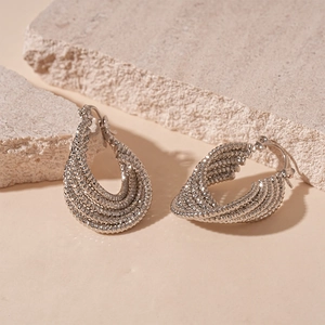 Detail of silver layered beaded earrings showing metallic texture and latch closure