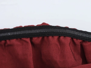 Close-up detail of the red ethnic print fabric with black elastic waistband stitching
