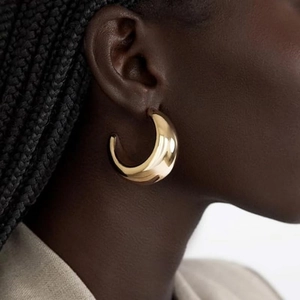 Polished 18K gold plated chunky C-shaped hoop earrings for women on a model