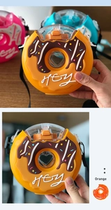 Detail of orange donut-shaped water bottle with straw, shoulder strap and 'HEY' logo