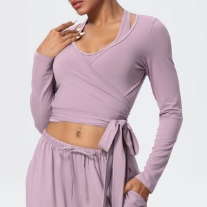 Detailed wrap design of mauve long-sleeve yoga top with waist tie and inner tank top