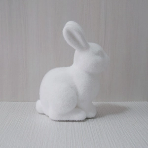 Detailed view of white plush rabbit decoration with soft texture on a wooden desk