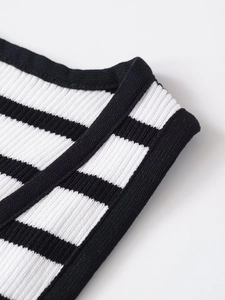 Macro detail of the high-quality knit texture and black-white stripes on the V-neck vest