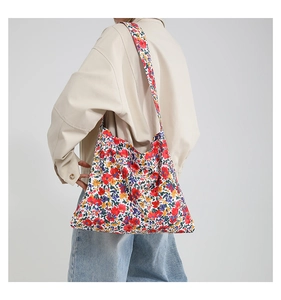 Detail view of the vibrant floral print shoulder bag on canvas fabric with a large strap