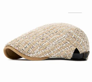 Detail of khaki knitted flat cap showing tweed texture and leather adjustment strap