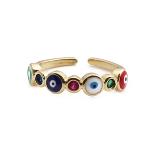 Détail d'une bague dorée avec yeux protecteurs colorés et incrustations de zircon