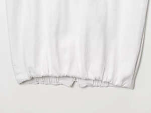 Détail de la texture en sergé blanc avec ourlet élastique et fermeture éclair en métal