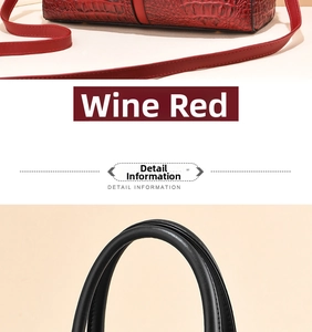 Detail of burgundy crocodile embossed handbag and stitching on black leather handle