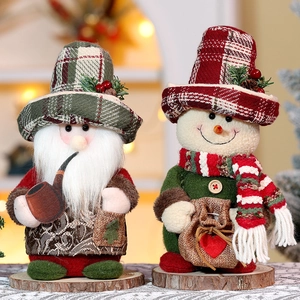 Standing Christmas Santa and snowman dolls with plaid hats on wooden surface decoration