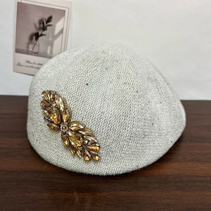 Gray knitted beret with amber rhinestone flower and glitter thread for a stylish winter look