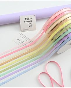 Macro detail of 1cm satin ribbons in pastel colors with heart-shaped pink ribbon styling