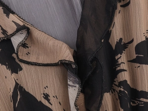 Detail of tan chiffon fabric with black brushstroke prints and ruffled hem stitching