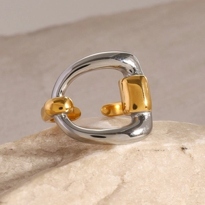 Minimalist gold and silver two-tone irregular open ring on a natural stone base