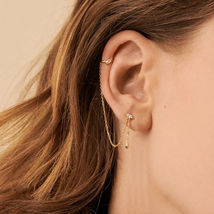 Detail of gold chain earring with marquise opal stone and ear cuff on female model