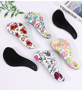 Flat lay of colorful floral and graffiti patterned hairbrushes on a white desk