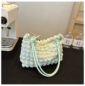 Detail of mint green puffed texture handbag with elastic bubble structure and handle