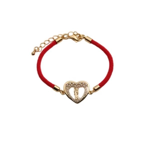 Macro detail of red string bracelet with gold heart charm and adjustable lobster clasp