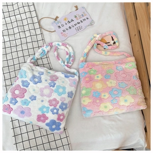 Close-up of soft plush tote bags featuring colorful floral patterns and woven straps