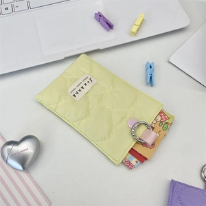 Detail of light yellow quilted heart card holder with SOZAKKA label and metal ring hook