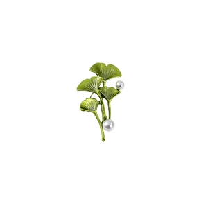 Detail showing green ginkgo leaf brooch with white pearls and gold-tone stem