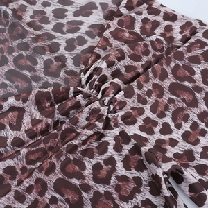 Détail rapproché du tissu imprimé léopard avec texture froncée et coutures sur la jambe