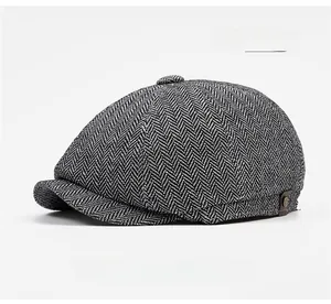 Close-up of light gray herringbone newsboy cap with textured wool blend fabric detail
